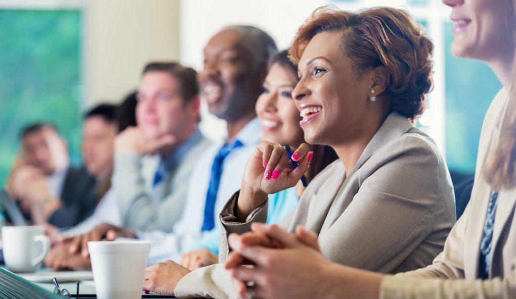 Several People Seated In A Meeting Space